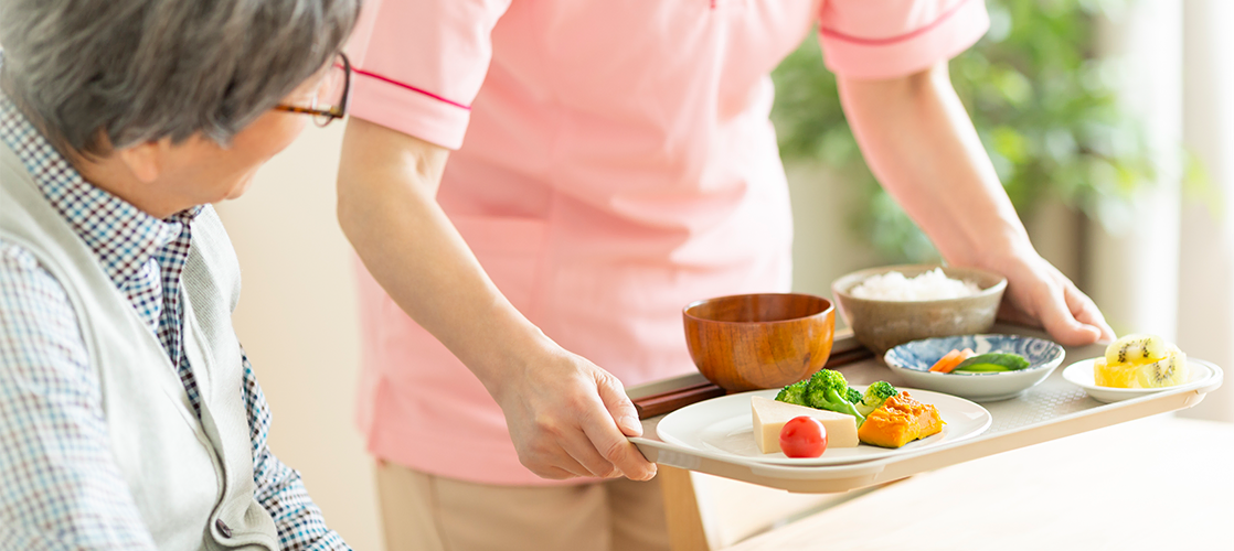 入院中の患者さんに食事を配膳する看護師